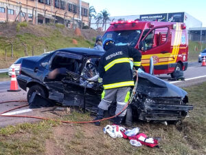 Bombeiro socorre ocupantes do automóvel preto 